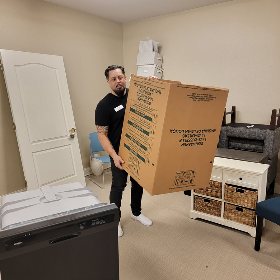 A man holding a box in a room with furniture.