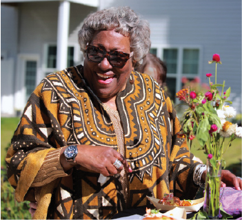 Senior resident outside laughing with flowers