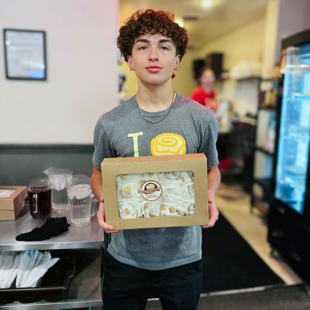 A young man at a local business holds a gift given by The Madison Senior Living.