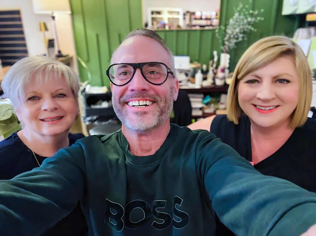 A man and two women take a photo together at a local business.